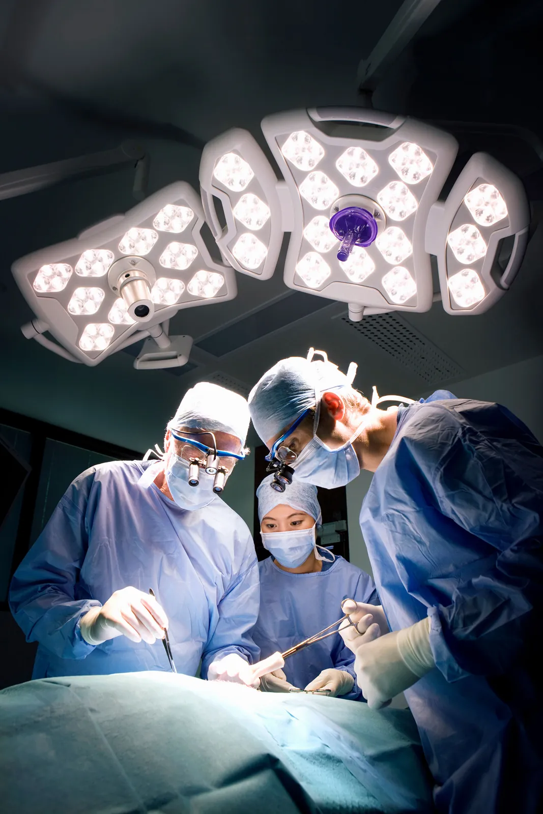 A surgical team at work under operating theatre lights